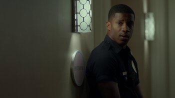 Movie still from “Beyond the Lights” (2014), directed by Gina Prince-Bythewood – A police officer standing in front of a wall; Medium shot, Over the shoulder angle