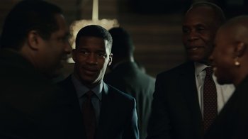 Movie still from “Beyond the Lights” (2014), directed by Gina Prince-Bythewood – A man in a suit and tie standing next to two other men; Close Up shot, Over the shoulder angle