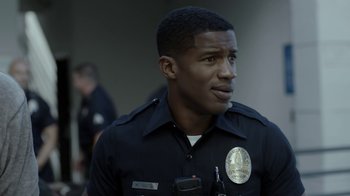 Movie still from “Beyond the Lights” (2014), directed by Gina Prince-Bythewood – A police officer is looking into the distance; Close Up shot, Over the shoulder angle