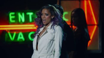 Movie still from “Beyond the Lights” (2014), directed by Gina Prince-Bythewood – A woman with purple hair standing in front of a neon sign; Medium shot, Low angle