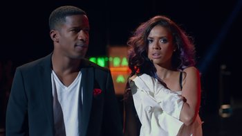 Movie still from “Beyond the Lights” (2014), directed by Gina Prince-Bythewood – A man and a woman standing next to each other in front of a neon sign; Medium shot, Low angle