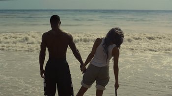 Movie still from “Beyond the Lights” (2014), directed by Gina Prince-Bythewood – A man and a woman holding hands on the beach; Wide shot, High angle