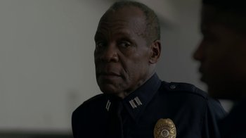 Movie still from “Beyond the Lights” (2014), directed by Gina Prince-Bythewood – A man in a police uniform with a badge on his chest; Close Up shot, Over the shoulder angle