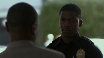 Movie still from “Beyond the Lights” (2014), directed by Gina Prince-Bythewood – A police officer talking to another person; Close Up shot, Over the shoulder angle