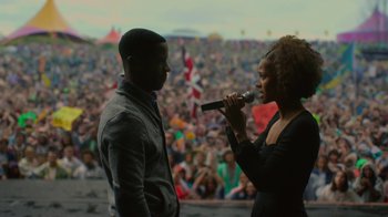 A man and a woman are on a stage with a crowd