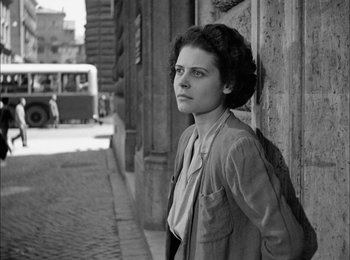 Movie still from “Bicycle Thieves” (1948), directed by Vittorio De Sica – Black and white photograph of a woman leaning against a wall; Medium shot, Low angle