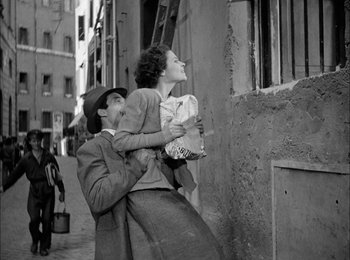 Movie still from “Bicycle Thieves” (1948), directed by Vittorio De Sica – An old photo of a woman holding a child; Medium shot, Low angle