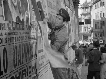 Movie still from “Bicycle Thieves” (1948), directed by Vittorio De Sica – An old photo of a man painting a wall; Wide shot, Low angle
