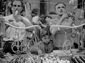 Movie still from “Bicycle Thieves” (1948), directed by Vittorio De Sica – A black and white photo of a man and a boy; Medium shot, High angle