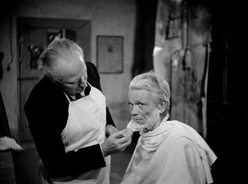 Movie still from “Bicycle Thieves” (1948), directed by Vittorio De Sica – An old man getting his hair cut by a barber; Medium shot, Over the shoulder angle