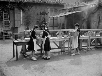 Movie still from “Bicycle Thieves” (1948), directed by Vittorio De Sica – A group of women standing next to each other in front of a table; Wide shot, High angle