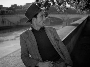 Movie still from “Bicycle Thieves” (1948), directed by Vittorio De Sica – A black and white photo of a man wearing a hat; Medium shot, High angle