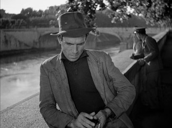 Movie still from “Bicycle Thieves” (1948), directed by Vittorio De Sica – A black and white photo of a man wearing a hat; Medium shot, High angle