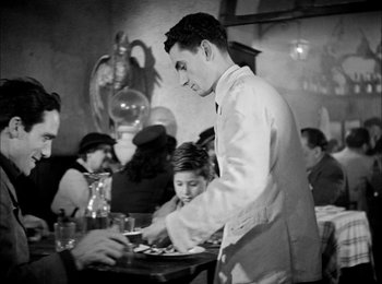 Movie still from “Bicycle Thieves” (1948), directed by Vittorio De Sica – A man serving a plate of food at a restaurant; Medium shot, Low angle