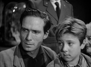 Movie still from “Bicycle Thieves” (1948), directed by Vittorio De Sica – A black and white photo of a man and a young boy; Close Up shot, Over the shoulder angle
