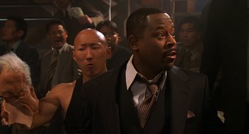 Movie still from “Big Momma's House” (2000), directed by Raja Gosnell – A man in a suit and tie standing next to another man in a suit and tie; Close Up shot, Over the shoulder angle