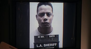 Movie still from “Big Momma's House” (2000), directed by Raja Gosnell – A mugshot of a man in a white t - shirt; Extreme Close Up shot, Low angle