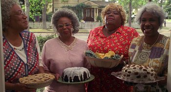 Movie still from “Big Momma's House” (2000), directed by Raja Gosnell – Two older women holding cakes and pies in front of a house; Medium shot, High angle