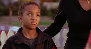 Movie still from “Big Momma's House” (2000), directed by Raja Gosnell – A young boy sitting in front of an adult; Close Up shot, Over the shoulder angle