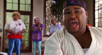 Movie still from “Big Momma's House” (2000), directed by Raja Gosnell – A man in a white shirt and a blue hat; Close Up shot, Low angle