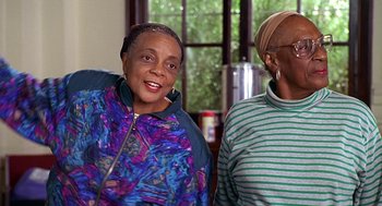 Movie still from “Big Momma's House” (2000), directed by Raja Gosnell – Two older women standing next to each other in front of a window; Medium shot, Low angle