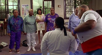 Movie still from “Big Momma's House” (2000), directed by Raja Gosnell – A group of people standing in a room; Medium shot, Over the shoulder angle