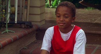 Movie still from “Big Momma's House” (2000), directed by Raja Gosnell – A young boy sitting on the ground in a red shirt; Close Up shot, High angle