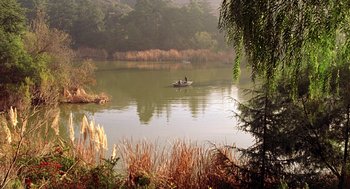 Movie still from “Big Momma's House” (2000), directed by Raja Gosnell – Two people in a small boat on a lake surrounded by trees and bushes; Extreme Wide shot, High angle