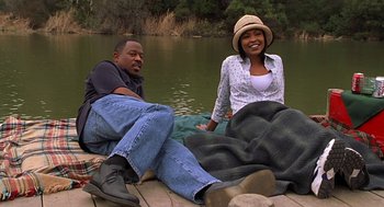 Movie still from “Big Momma's House” (2000), directed by Raja Gosnell – A man and a woman sitting on a dock by a body of water; Medium shot, High angle