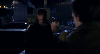 Movie still from “Big Momma's House” (2000), directed by Raja Gosnell – A man holding a gun in front of another man in the dark; Medium shot, Over the shoulder angle