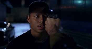 Movie still from “Big Momma's House” (2000), directed by Raja Gosnell – A man holding a gun up to his face; Close Up shot, Over the shoulder angle