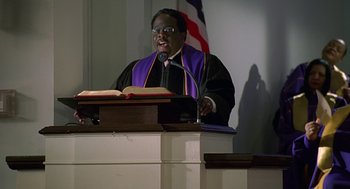Movie still from “Big Momma's House” (2000), directed by Raja Gosnell – A man is giving a sermon at a church; Medium shot, Low angle
