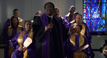 Movie still from “Big Momma's House” (2000), directed by Raja Gosnell – A man in a purple and yellow choir robe; Medium shot, High angle