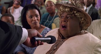 Movie still from “Big Momma's House” (2000), directed by Raja Gosnell – A woman is being interviewed by a microphone; Close Up shot, Low angle