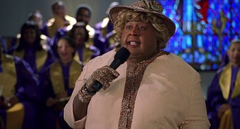 Movie still from “Big Momma's House” (2000), directed by Raja Gosnell – A man in a hat and a microphone; Close Up shot, High angle