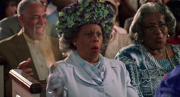 Movie still from “Big Momma's House” (2000), directed by Raja Gosnell – An older woman wearing a hat with flowers on it; Close Up shot, Low angle