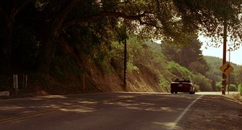 Movie still from “Big Momma's House” (2000), directed by Raja Gosnell – A car driving down a road next to trees; Extreme Wide shot, High angle