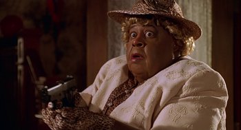 Movie still from “Big Momma's House” (2000), directed by Raja Gosnell – An older woman in a brown hat holding a gun in her hand; Close Up shot, High angle