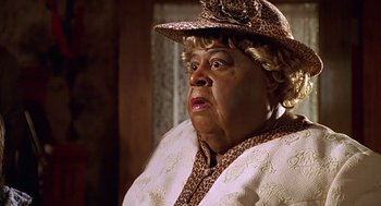 Movie still from “Big Momma's House” (2000), directed by Raja Gosnell – An older woman wearing a brown hat and a white dress; Close Up shot, Low angle