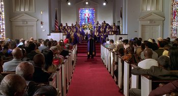 Movie still from “Big Momma's House” (2000), directed by Raja Gosnell – A church with people in the pews and a choir singing; Extreme Wide shot, High angle