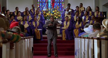 Movie still from “Big Momma's House” (2000), directed by Raja Gosnell – A group of people sitting in front of stained glass windows; Wide shot, Low angle