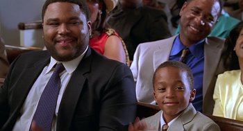 Movie still from “Big Momma's House” (2000), directed by Raja Gosnell – A man and a boy sitting in front of other people; Close Up shot, Over the shoulder angle