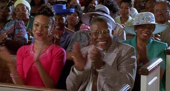 Movie still from “Big Momma's House” (2000), directed by Raja Gosnell – A group of people sitting in a room clapping; Medium shot, Low angle