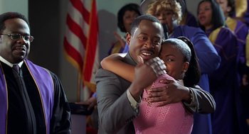 Movie still from “Big Momma's House” (2000), directed by Raja Gosnell – A man and a woman hugging in front of an american flag; Close Up shot, Over the shoulder angle