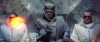 Movie still from “Bill & Ted's Excellent Adventure” (1989), directed by Stephen Herek – A man sitting in a chair wearing sunglasses and a hat; Medium shot, Low angle