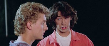 Movie still from “Bill & Ted's Excellent Adventure” (1989), directed by Stephen Herek – Two young men talking to each other in front of a black background; Close Up shot, Over the shoulder angle