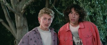 Movie still from “Bill & Ted's Excellent Adventure” (1989), directed by Stephen Herek – A couple of people standing next to each other in front of a tree; Close Up shot, Low angle