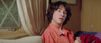 Movie still from “Bill & Ted's Excellent Adventure” (1989), directed by Stephen Herek – A young man sitting on top of a white couch; Close Up shot, Overhead angle