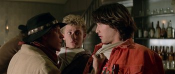 Movie still from “Bill & Ted's Excellent Adventure” (1989), directed by Stephen Herek – A group of young men standing next to each other in a room; Close Up shot, Over the shoulder angle