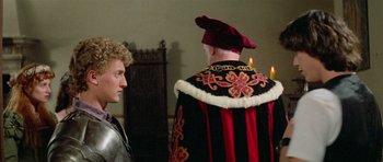 Movie still from “Bill & Ted's Excellent Adventure” (1989), directed by Stephen Herek – A man in a suit of a medieval knight standing next to a man in a red and black suit; Medium shot, Over the shoulder angle